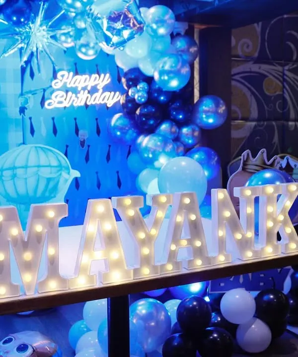 We bring popular themes to life for birthday parties, like this "Boss Baby" themed celebration. The setup includes a custom backdrop, marquee lights with the birthday boy's name, and a coordinated blue balloon arrangement for a stylish event.