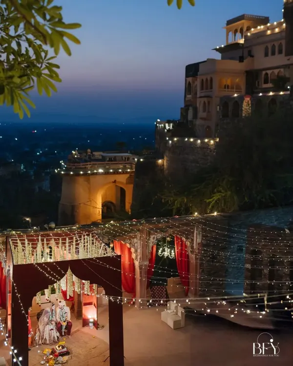 A magical wedding ceremony at dusk, with the historic Neemrana Fort-Palace illuminated against the twilight sky, creating a truly royal and unforgettable ambiance.