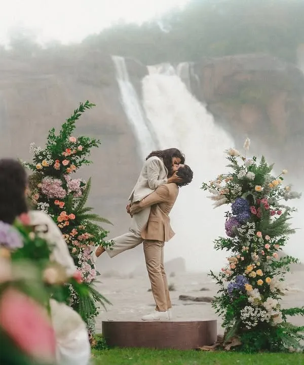 A kiss that feels as powerful as the falls behind them. This shot from Gokul and Vandana's vow renewal at Athirappilly shows how we can create a truly epic moment, framed by nature's grandeur and beautiful floral decor.