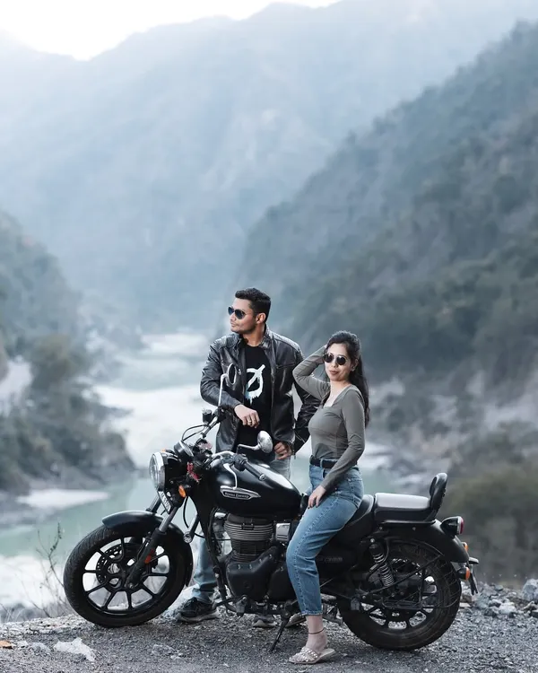 A classic biker couple pose against the stunning backdrop of the river and mountains near Rishikesh. The leather jackets and cool sunglasses complete the edgy, adventurous vibe of this pre-wedding shoot.
