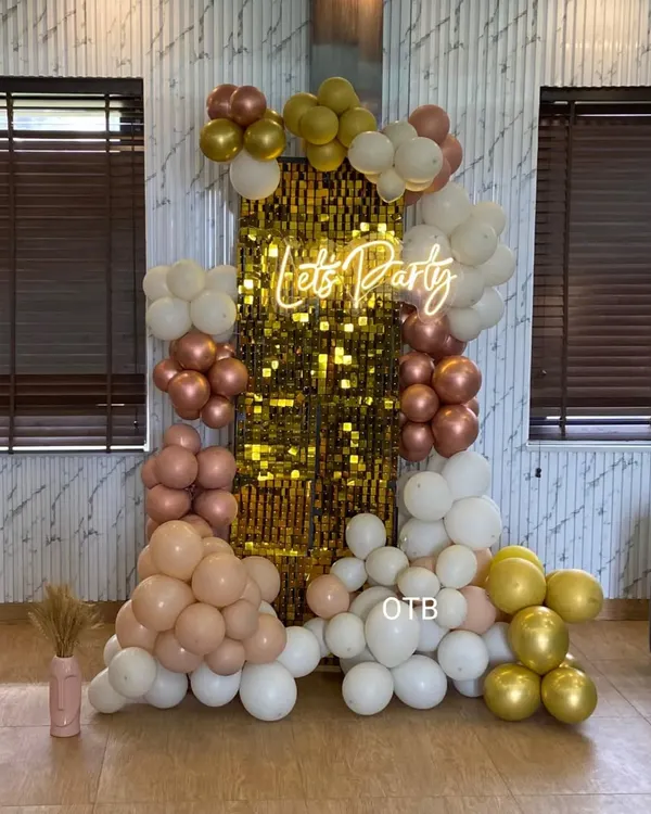 This is the same popular 'Let's Party' setup with a gold sequin wall and pastel balloon garland, shown here in a home setting. It's a versatile backdrop that works for any modern celebration.