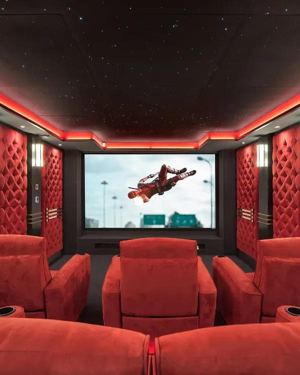 Experience cinematic perfection in this vibrant, red-themed theater. We designed this space with plush, tiered recliner seating, acoustically treated walls with diamond-tufted panels, and a state-of-the-art projection system for an unparalleled viewing experience.