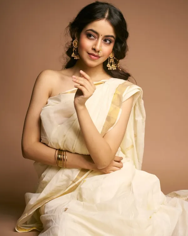 A moment of quiet grace. This look, inspired by classic Indian aesthetics, features soft makeup that enhances natural beauty, paired with a simple white and gold saree for a truly ethereal feel.