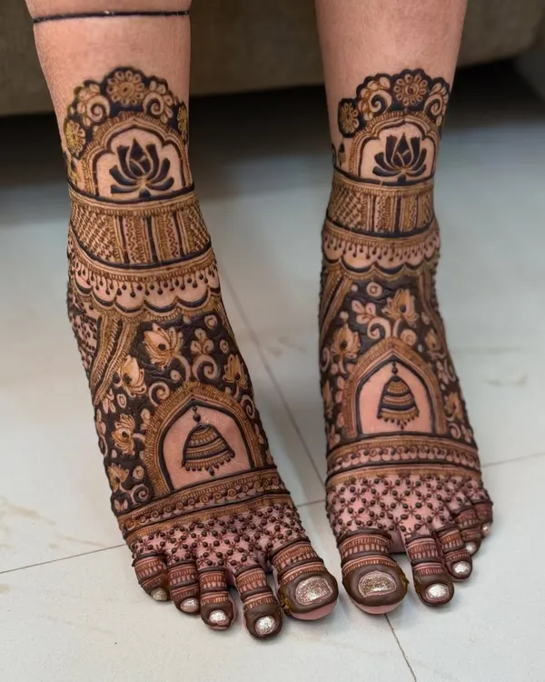A classic bridal feet design featuring beautiful temple bells and lotus motifs. The patterns are symmetrical and create a stunning look, perfect for a traditional bride.