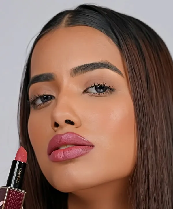 A striking close-up for a lipstick ad, showcasing a soft pink shade. The clean lighting and tight crop emphasize the product's texture and the model's features.