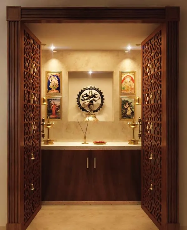 This pooja unit features beautifully CNC-carved doors and a contrasting color combination inside the mandir for a great view. The design is both traditional and elegant, creating a perfect space for prayer.