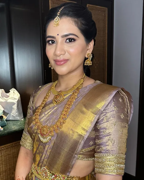 A simple yet elegant engagement look in a traditional silk saree. The makeup is minimal to let the classic jewelry and attire shine.