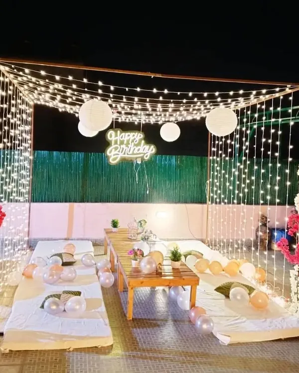 This is how I transform an open terrace into a magical, private space for a birthday celebration. The setup includes low seating, a canopy of fairy lights, and a custom neon sign to create an unforgettable ambiance under the stars.