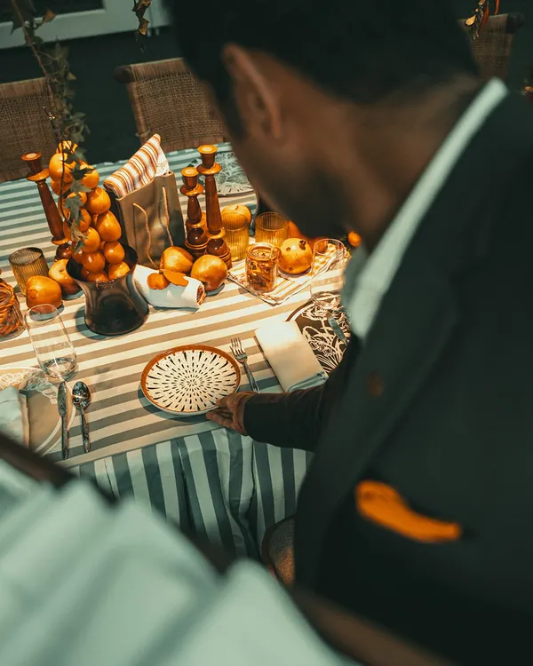 A guest admires an impeccably set table with a vibrant, citrus-themed decor.
