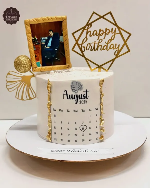 A unique birthday cake featuring a photo in an edible gold frame and a calendar marking the special day. This is a great way to create a personalized and memorable gift.