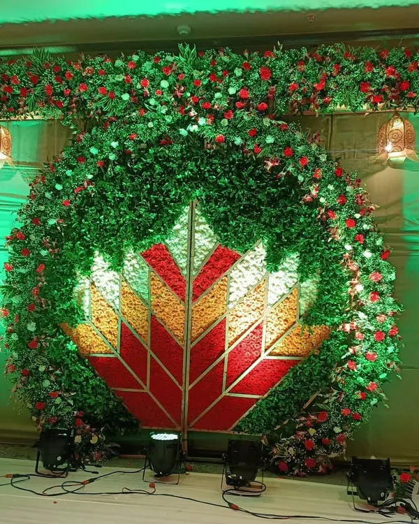 This is one of my most ambitious wedding backdrops, featuring a massive floral lotus design at its center. The entire structure is made of lush greenery and red roses, creating a breathtaking and grand entrance for the couple.