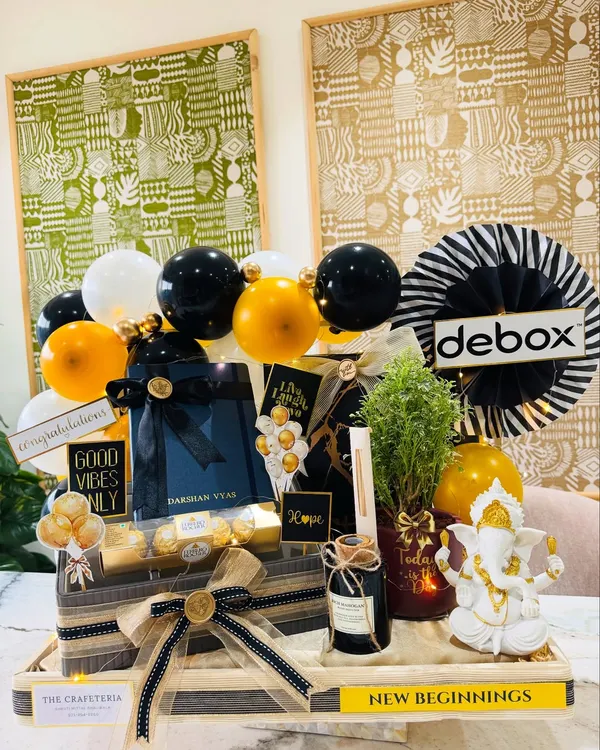 A full view of our 'New Beginnings' hamper, created for a son-in-law's office inauguration. The client wanted something elegant and masculine, so we built this arrangement with a Ganesha idol, a live Arailia plant, and a personalized diary, all in a striking black and gold palette.