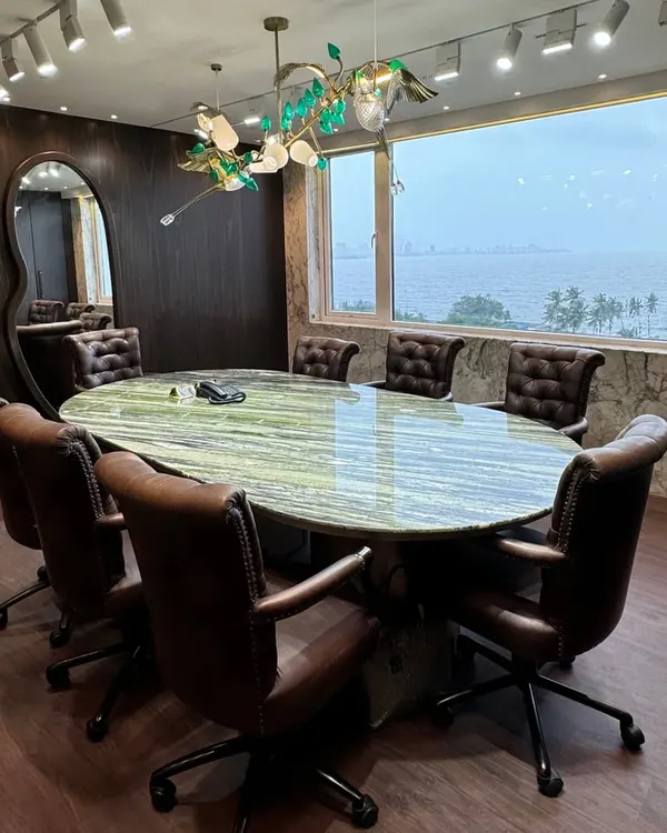 This sea-view conference room is designed to inspire. We combined a stunning green marble table, rich leather chairs, and a custom bird-themed chandelier to create a space that feels both powerful and serene, letting the incredible view do the rest.