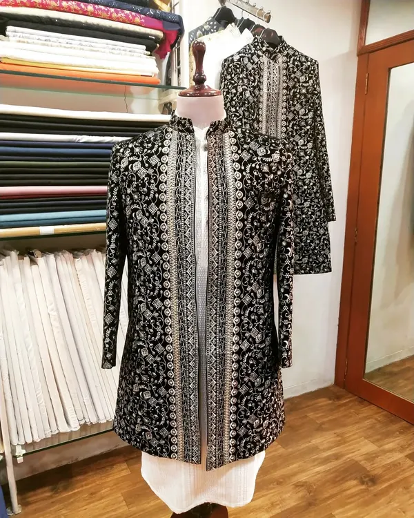 This black and silver open-front Jodhpuri jacket showcases our skill in detailed patterns. The intricate design provides a sophisticated and modern look, perfect for a wedding reception or formal event.
