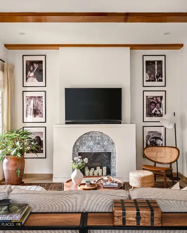This family room is designed for cozy movie nights and quality time. The large sectional faces the custom fireplace and TV unit, while the wooden ceiling beams and layered rugs add warmth and texture. It's a perfect example of a comfortable, lived-in luxury design.
