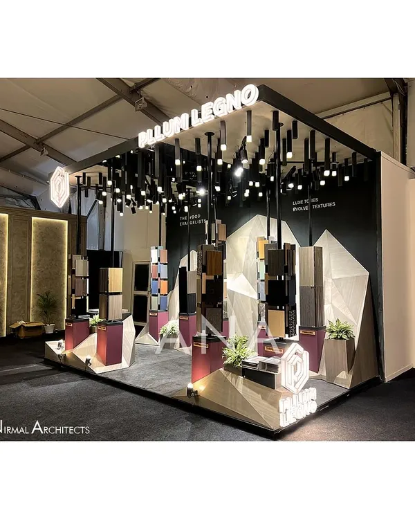 For Pllum Legno's 15 sq.m stall, we created an art installation instead of a traditional pavilion. This side view shows the dramatic lighting and sculptural display stands set against an abstract, faceted background.