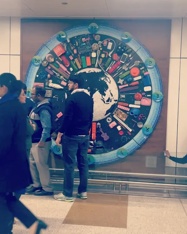 The finished mural installed at the airport, seen by people from all over the world. It is designed to make people pause and think about consumption and the environment, even in a busy travel hub.
