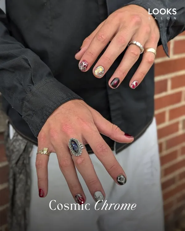 Nail art is a form of self-expression for everyone. This 'Cosmic Chrome' design for men features a mix of bold colors and metallic accents for a confident and stylish look.