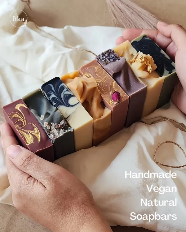 This is a handful of my art. I'm holding a loaf of freshly cut cold-process soaps, showing the unique colors, swirls, and textures of each natural, vegan, and handmade bar.