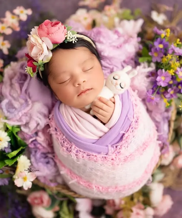 This baby girl is sleeping so peacefully, surrounded by a bed of lavender and pink flowers. I carefully arrange each floral element to create a lush, garden-like feel for the portrait.