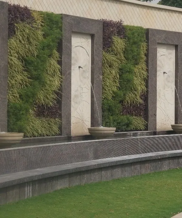 This large-scale exterior wall combines the soothing element of water with the natural beauty of vertical gardens. We designed this installation with repeating sections of living walls and elegant water fountains, creating a grand and serene feature for a commercial property.