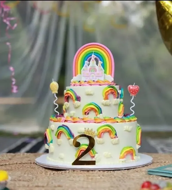 A fantastic rainbow-themed cake for a second birthday party. I always capture a beautiful shot of the cake before it's cut, preserving the memory of its creative design.