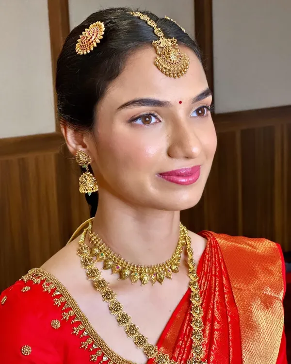 This is a perfect example of a soft and subtle Muhurtham makeup look for Shreya, created entirely without false eyelashes. Her natural beauty shines through.