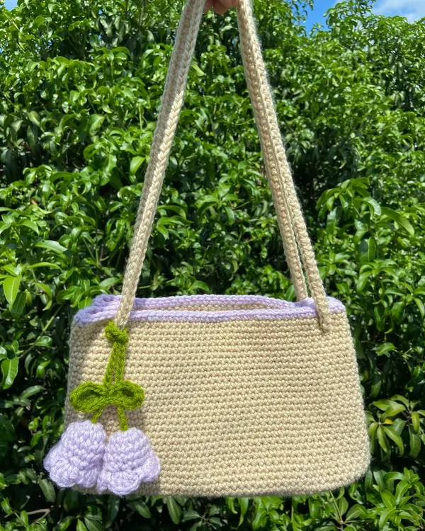 A beautiful custom shoulder bag in a neutral beige with a lovely lilac trim and tulip charm. This shows the kind of personalized work I can do for special orders.