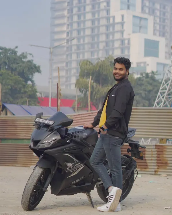 A full-length shot of the model standing next to his Yamaha R15. The urban background adds to the modern, cool feel of this men's portfolio photo.