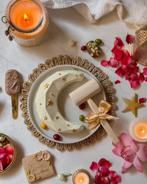 My Eid piñata set, featuring the geometric white chocolate moon, a decorated cookie, a cakesicle, and the wooden hammer to break into the fun. It's an interactive centerpiece for your Eid celebration.