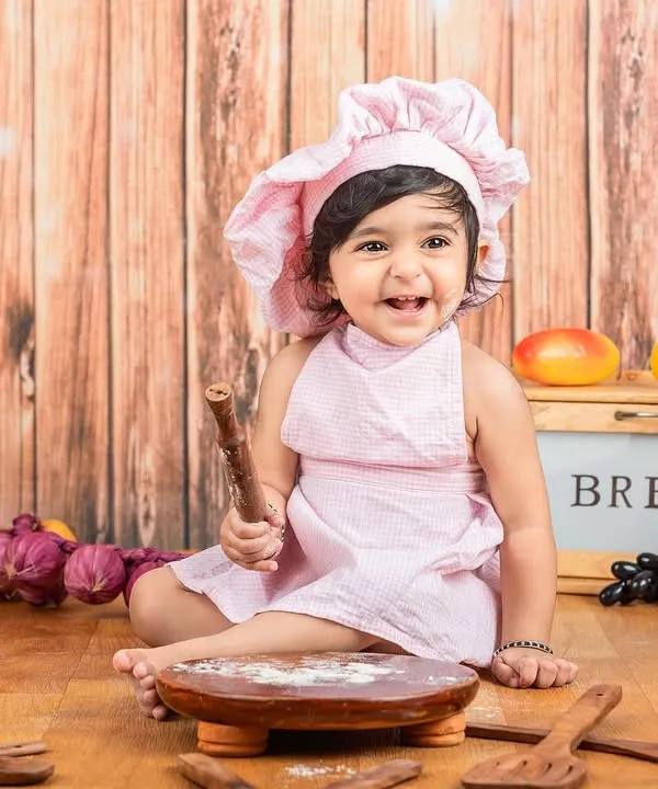 This mini masterchef is ready to bake something sweet! The pink chef hat and apron are just perfect for this little baker girl.