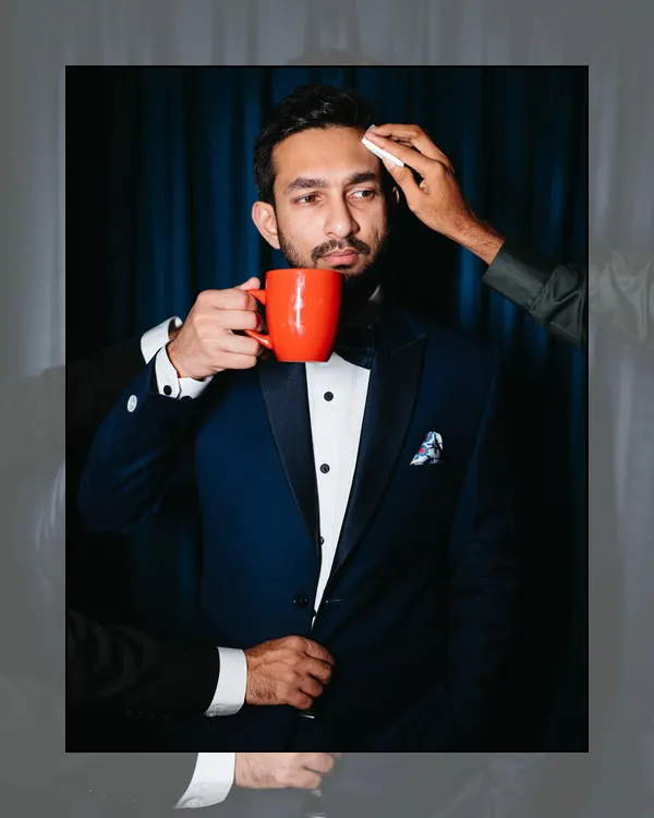 The groom, cool and composed with a coffee in hand, surrounded by his tribe. This creative shot captures the fun, chaos, and brotherhood of the getting-ready process.