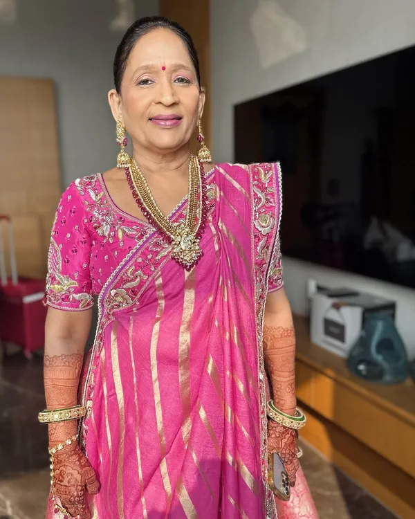 Elegant, sophisticated, and forever beautiful. This is the proud mother of the bride, looking radiant in a classic pink saree with makeup that enhances her natural grace.