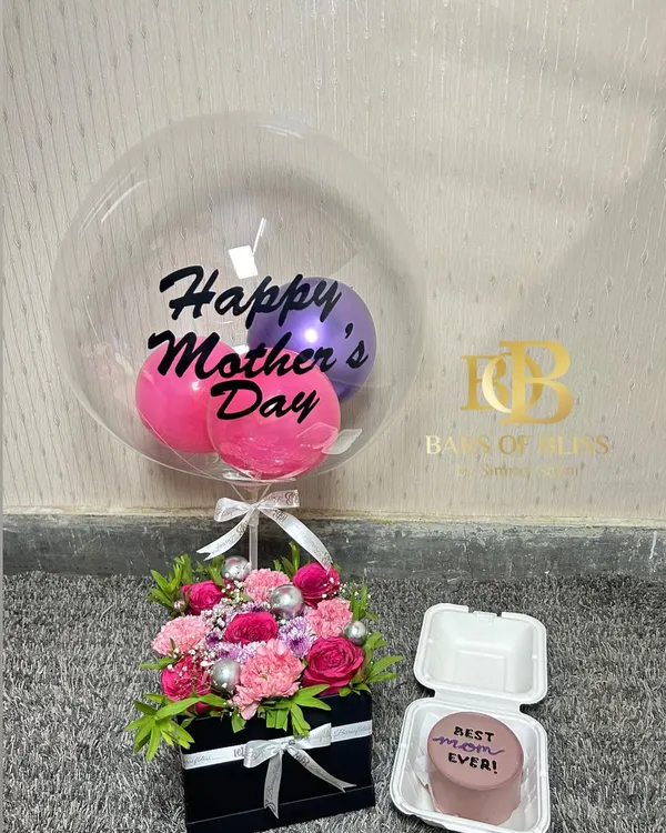 This Mother's Day hamper is a perfect gift, combining a beautiful floral arrangement in a box, a custom bento cake, and a "Happy Mother's Day" balloon.