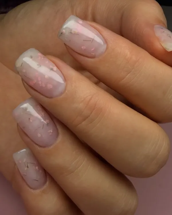 A perfect example of a hard gel overlay. This technique adds strength and structure to natural nails, as seen here with this beautiful milky manicure with delicate embedded threads.