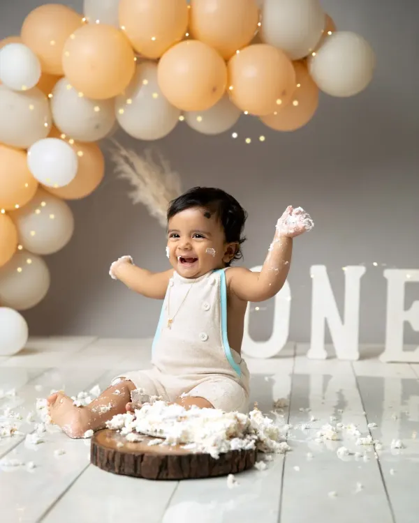Pure, unfiltered joy is what a first birthday cake smash is all about. I love capturing these moments of happy mess and sweet celebration against a simple, boho-inspired backdrop with soft balloon accents.