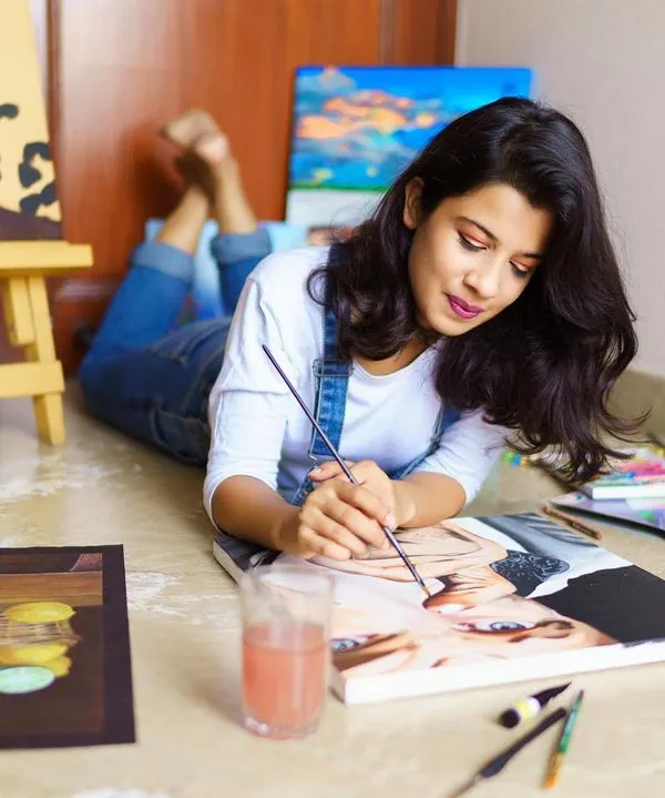 A snapshot of me enjoying the process, lying on the floor surrounded by my work. You can see a variety of pieces in different stages, from a leopard painting on an easel to a portrait I'm working on.