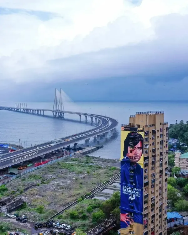 An absolutely massive mural of a young Amitabh Bachchan from his 'Deewar' days, overlooking the iconic Bandra-Worli Sea Link. This piece by the Bollywood Art Project is a landmark, merging cinematic history with the city's modern skyline.