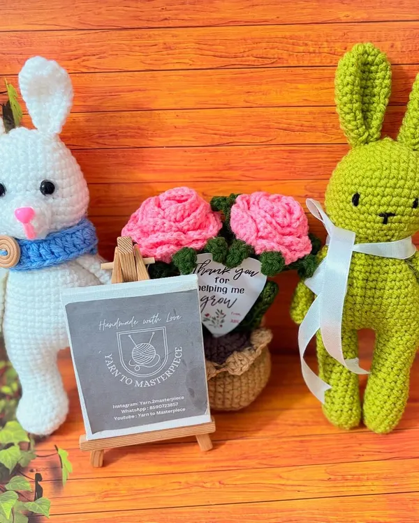 A friendly group of my handmade creations, featuring two crochet bunnies and a potted rose arrangement. This shows how my different pieces can be mixed and matched for a beautiful gift set.