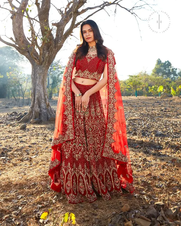For the bride who wants a classic look, this intricate red bridal lehenga is a dream come true. The detailed embroidery and cape-style dupatta create a regal silhouette for your big day.