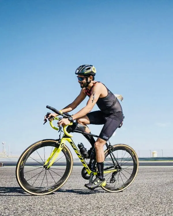 Focused and aerodynamic during the cycling leg of the Ironman 70.3 Bahrain. Our training prepares athletes for every segment of a triathlon, from swimming to this crucial bike portion.