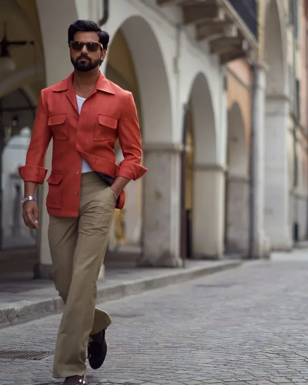 Our linen safari jacket in a vibrant Aperol spritz orange. This piece is perfect for warm days and cool evenings, offering a stylish layer for your travels.