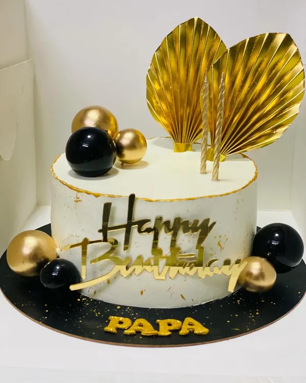 A classy black and gold themed cake for a father's birthday, exuding luxury and style.
