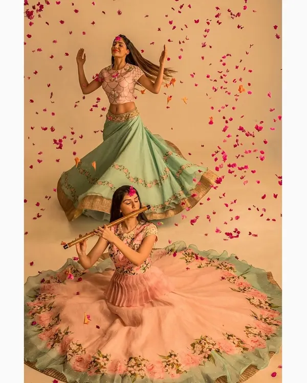 A creative fashion photograph for an Indian ethnic wear brand. The dynamic poses and falling petals create a whimsical and visually rich narrative for the collection's lookbook.
