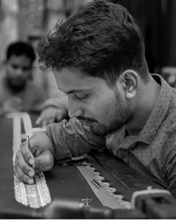 An artisan meticulously hand-painting a design onto fabric. This is where the unique beauty of our Kalamkari-inspired pieces begins.