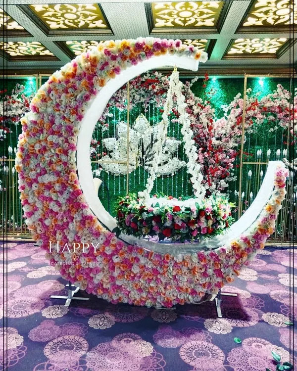 This is our most popular crescent moon cradle design for naming ceremonies. The cradle, adorned with a mix of pink and white flowers, is nestled inside the moon, creating a truly magical centerpiece for welcoming your little one.
