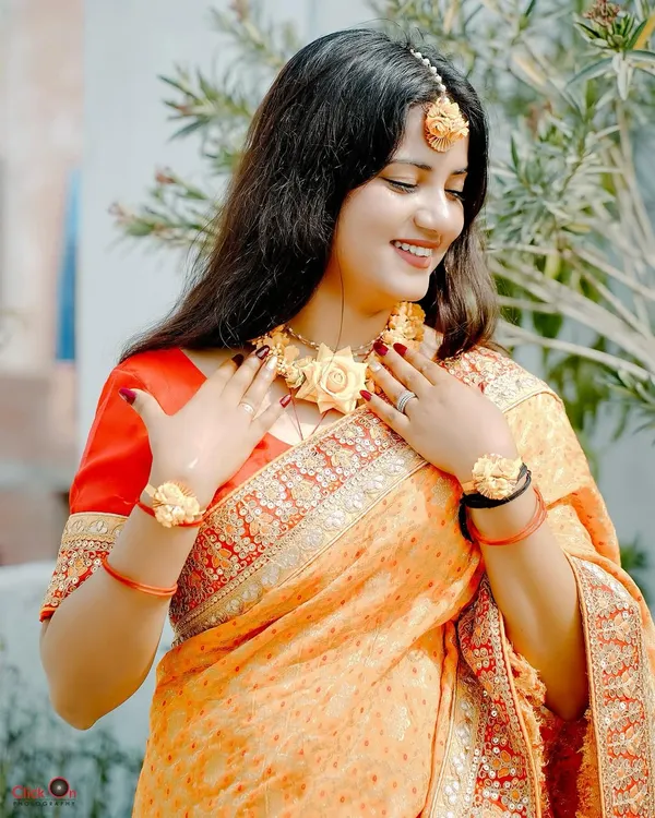 A beautiful candid shot of a bride during her Haldi ceremony, adorned with floral jewelry. We capture the natural glow and happiness of this sun-kissed ritual.