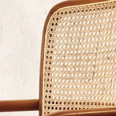 A close-up of the handwoven rattan back on my 'Romanji' chair. Teak wood has always been a key element in my designs, adding a feeling of comfort and pure bliss.