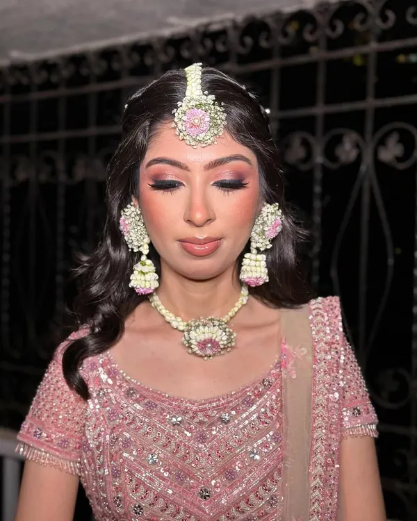 Desi vibes, but make it GLAM. For Kanika's mehendi sangeet, I created a dramatic smokey eye with pink undertones to match her stunning floral jewelry and lehenga.