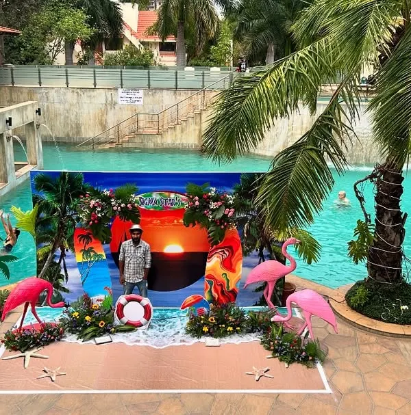 A spectacular beach-themed party setup at a resort pool. We created a mini-beach with a sunset backdrop, sand-colored flooring, and numerous props like flamingos and palm trees to create a tropical paradise.